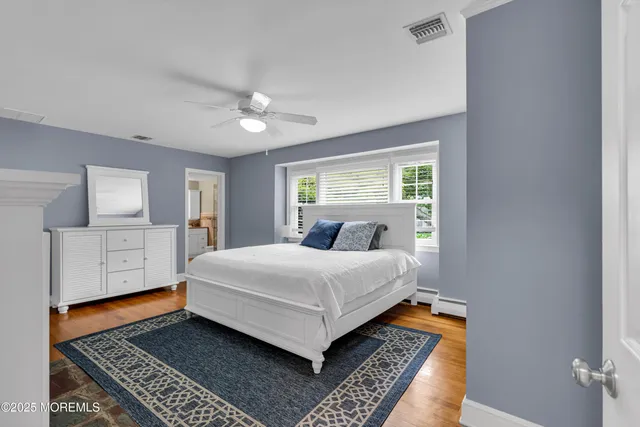 a bedroom with a white bed and dresser
