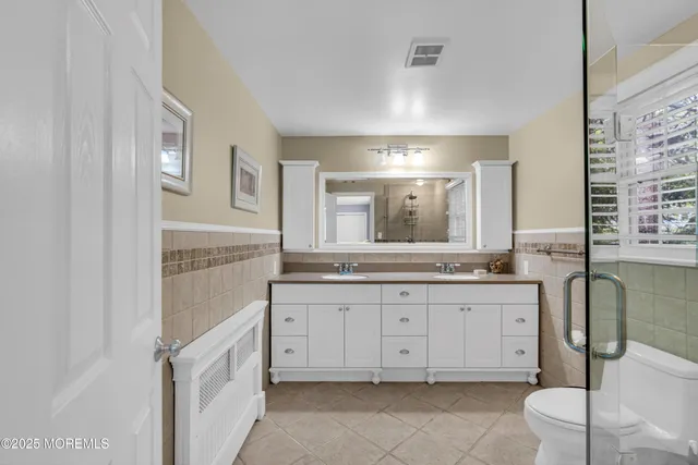 a bathroom with a granite countertop sink mirror and toilet