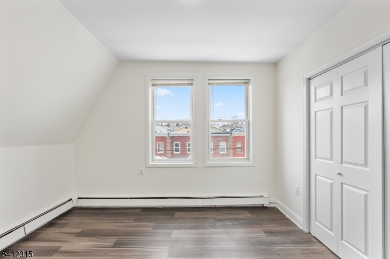 676 Chestnut Street, Unit 3 Kearny, NJ 07032 - Photo 13 of 21 an empty room with wooden floor and windows