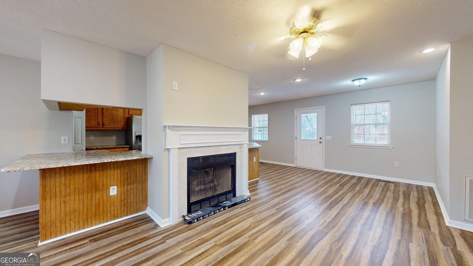 125 Harden Road Statesboro, GA 30458 - Photo 12 of 35 a view of a livingroom with a fireplace a ceiling fan and wooden floor