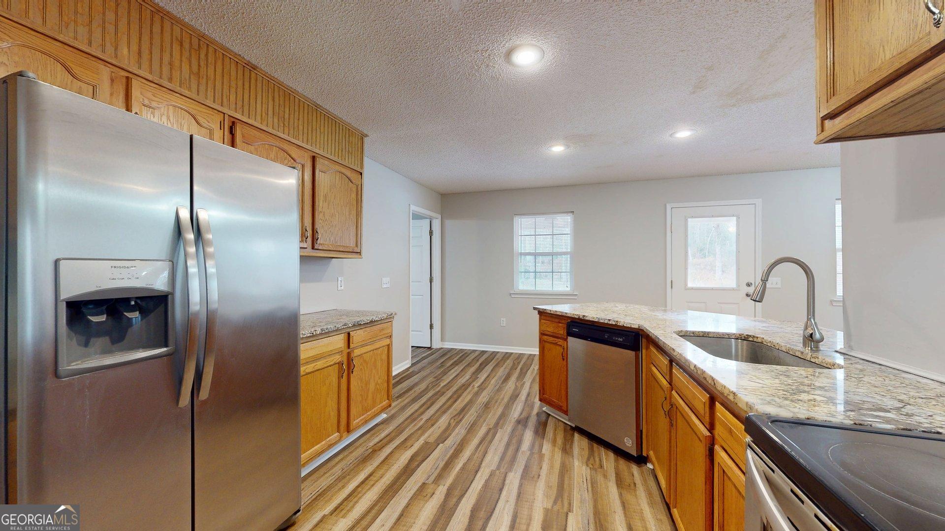 125 Harden Road Statesboro, GA 30458 - Photo 19 of 35 a kitchen with granite countertop stainless steel appliances a refrigerator a sink a stove and island