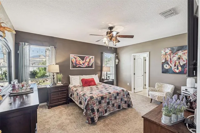 a bedroom with a bed a chandelier and a couch