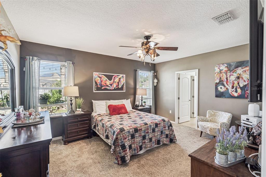 1183 Berkley Ridge Lane Auburndale, FL 33823 - Photo 11 of 25 a bedroom with a bed a chandelier and a couch