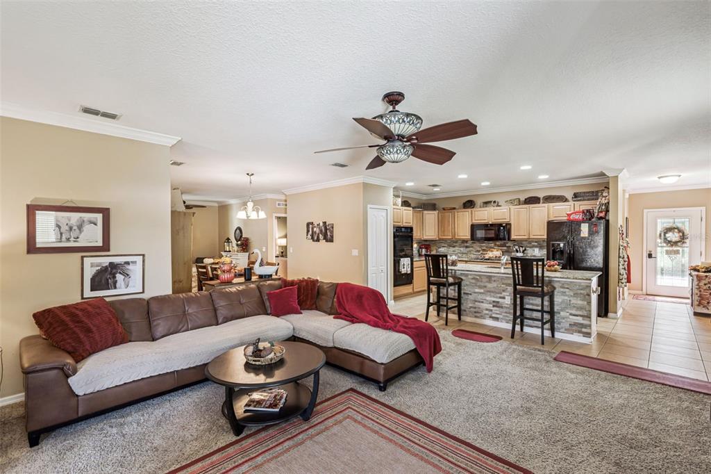 1183 Berkley Ridge Lane Auburndale, FL 33823 - Photo 4 of 25 a living room with furniture kitchen view and a chandelier