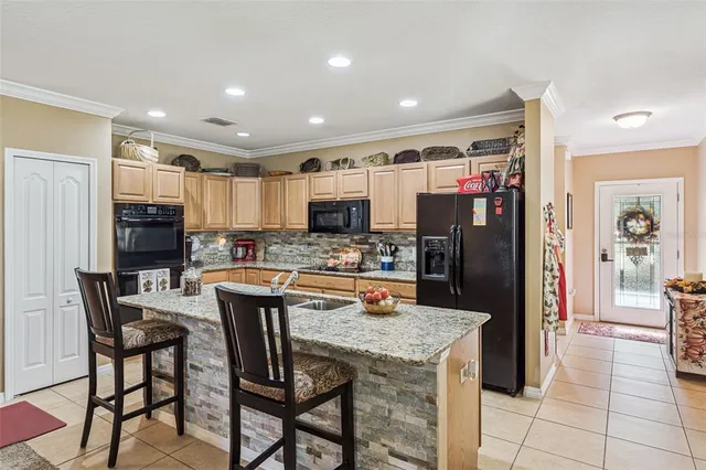 a kitchen with stainless steel appliances granite countertop a refrigerator and a stove top oven