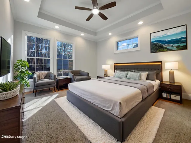 an empty room with windows and ceiling fan