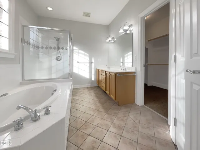 a bathroom with a tub sink shower and mirror