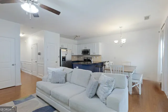 a living room with furniture and kitchen view