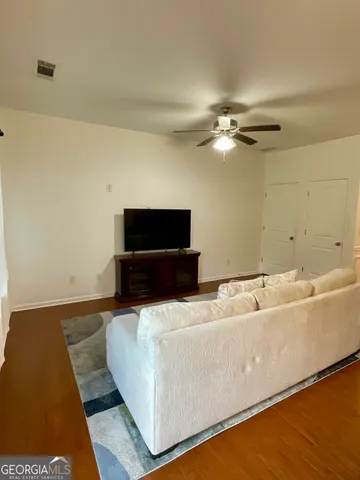 a living room with a couch and a ceiling fan