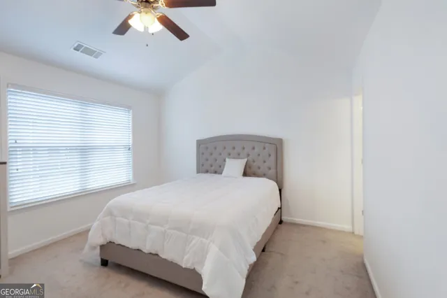 a large bed sitting in a bedroom next to a window