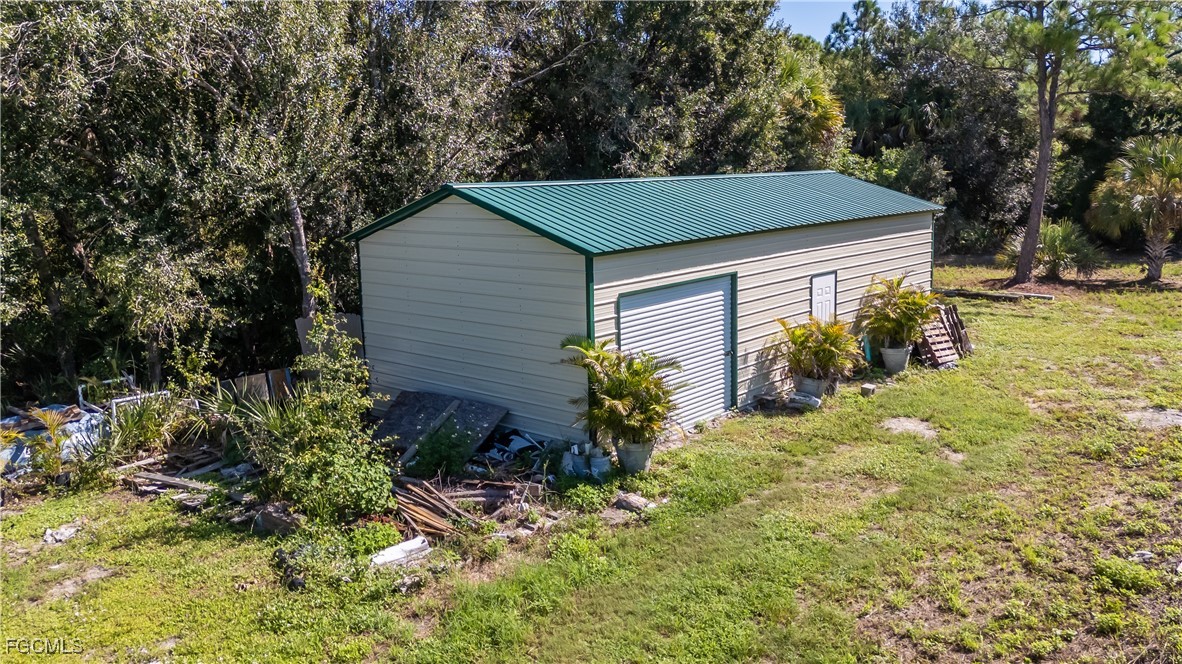 175 South Romero Street Clewiston, FL 33440 - Photo 3 of 19 a backyard of a house with plants and large trees