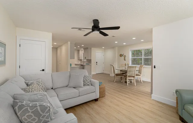 a living room with furniture and a view of kitchen