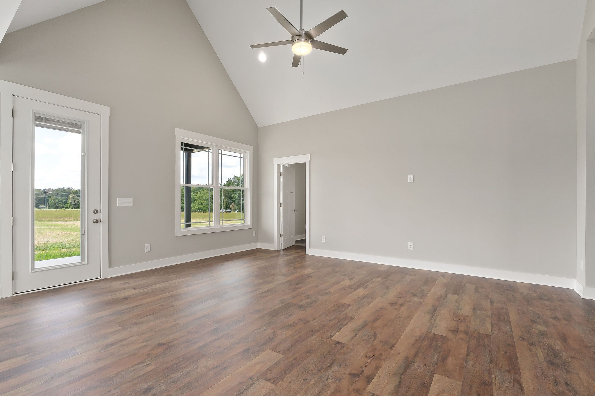 1095 Arch Cope Road Morrison, TN 37357 - Photo 6 of 29 an empty room with wooden floor ceiling fan and windows