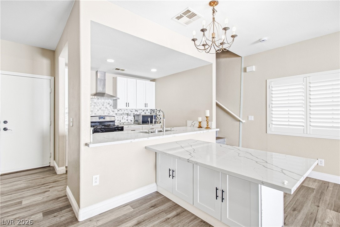 1475 Reef Ridge Court Las Vegas, NV 89128 - Photo 24 of 24 An open floor plan connects the kitchen with the dining area over quartz countertops.