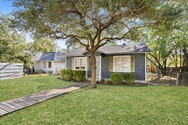 a front view of a house with a yard and trees