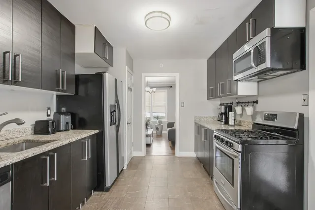 a kitchen with stainless steel appliances granite countertop a refrigerator stove top oven a sink and dishwasher