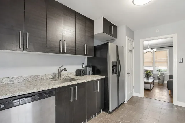 a kitchen with a sink a refrigerator and cabinets