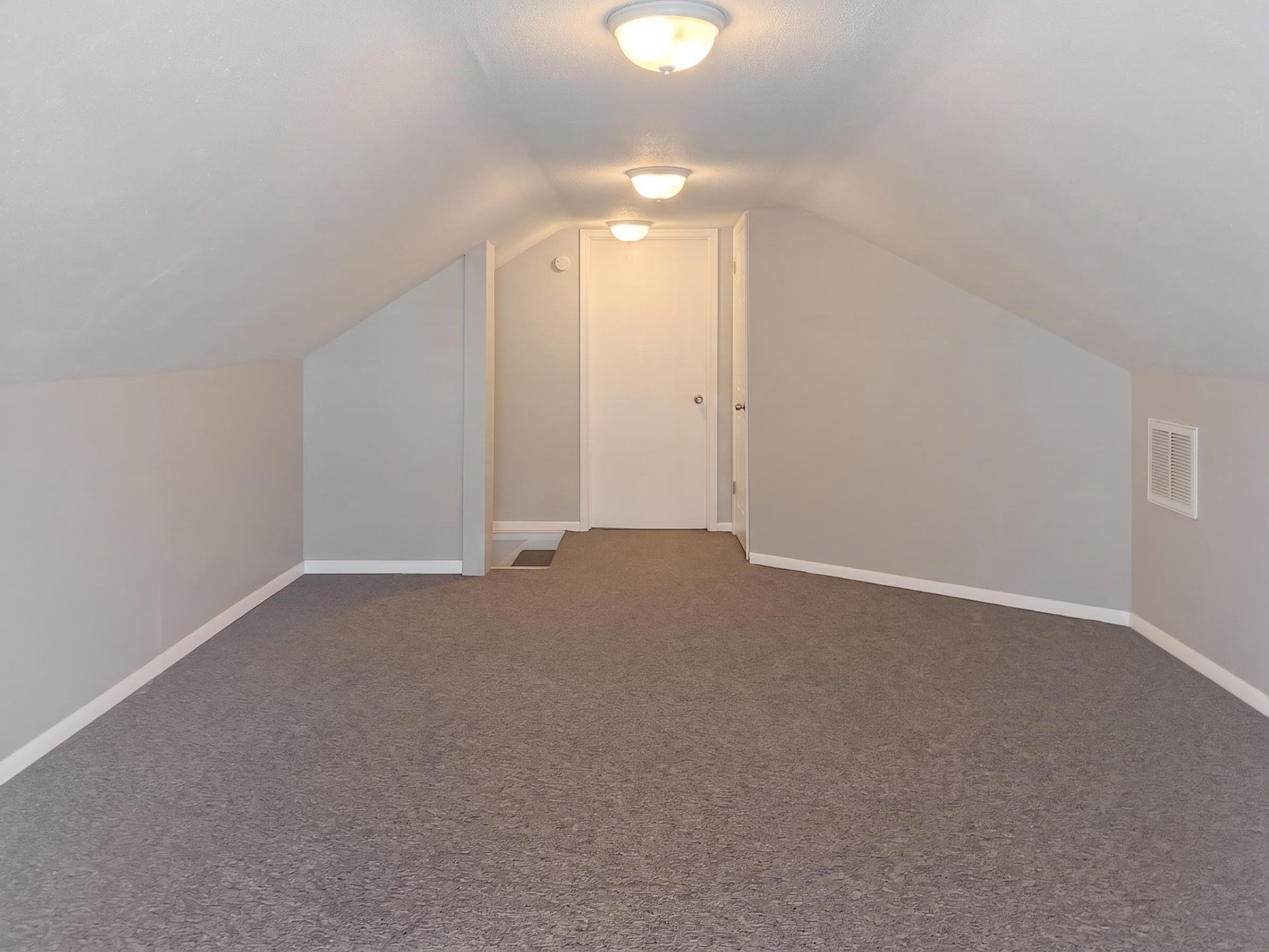 2313 Avenue L Rosenberg, TX 77471 - Photo 28 of 31 Expansive upstairs bonus room with carpet flooring, ideal for a game room, media room, home office, or additional living space.
