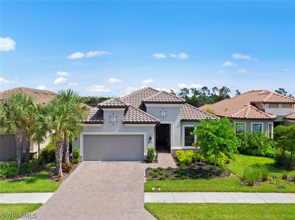 10238 Coconut Road Estero, FL 34135 - Photo 1 of 14 a front view of a house with a yard and garage