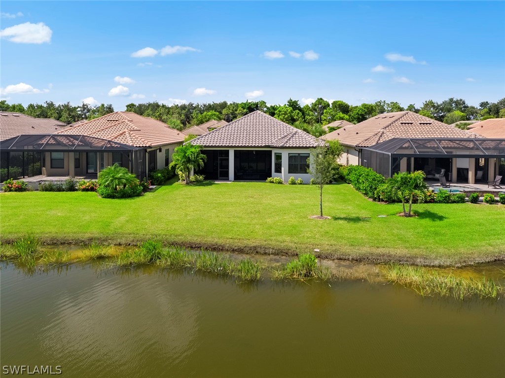 10238 Coconut Road Estero, FL 34135 - Photo 13 of 14 a view of a house with a yard and a swimming pool