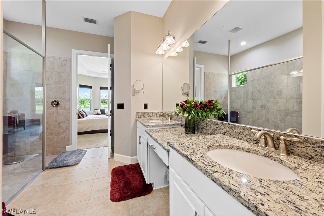 10238 Coconut Road Estero, FL 34135 - Photo 8 of 14 a spacious bathroom with a granite countertop sink and a mirror