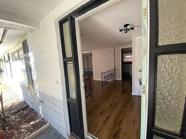 a view of a hallway with wooden floor and staircase
