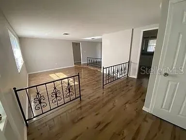 a view of a hallway with wooden floor