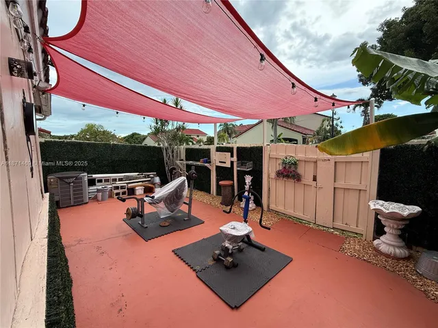 a view of a patio with a table and chairs under an umbrella