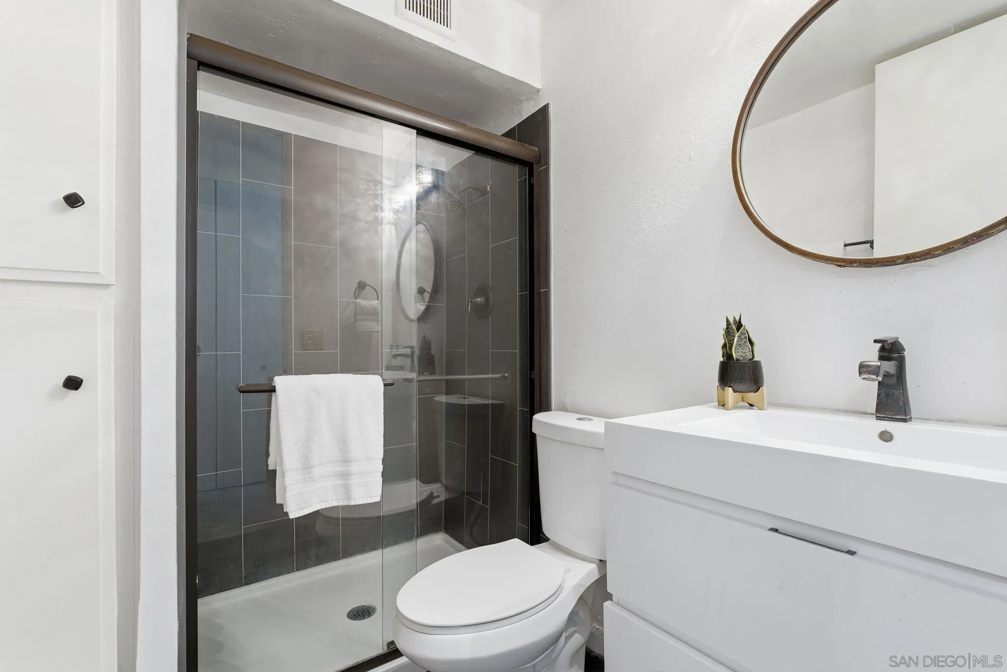 6455 La Jolla Boulevard, Unit 206 La Jolla, CA 92037 - Photo 17 of 24 a bathroom with a sink toilet and mirror