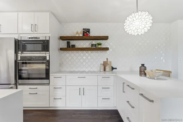 a kitchen with white cabinets and sink