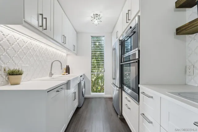 a kitchen with stainless steel appliances a sink and a refrigerator