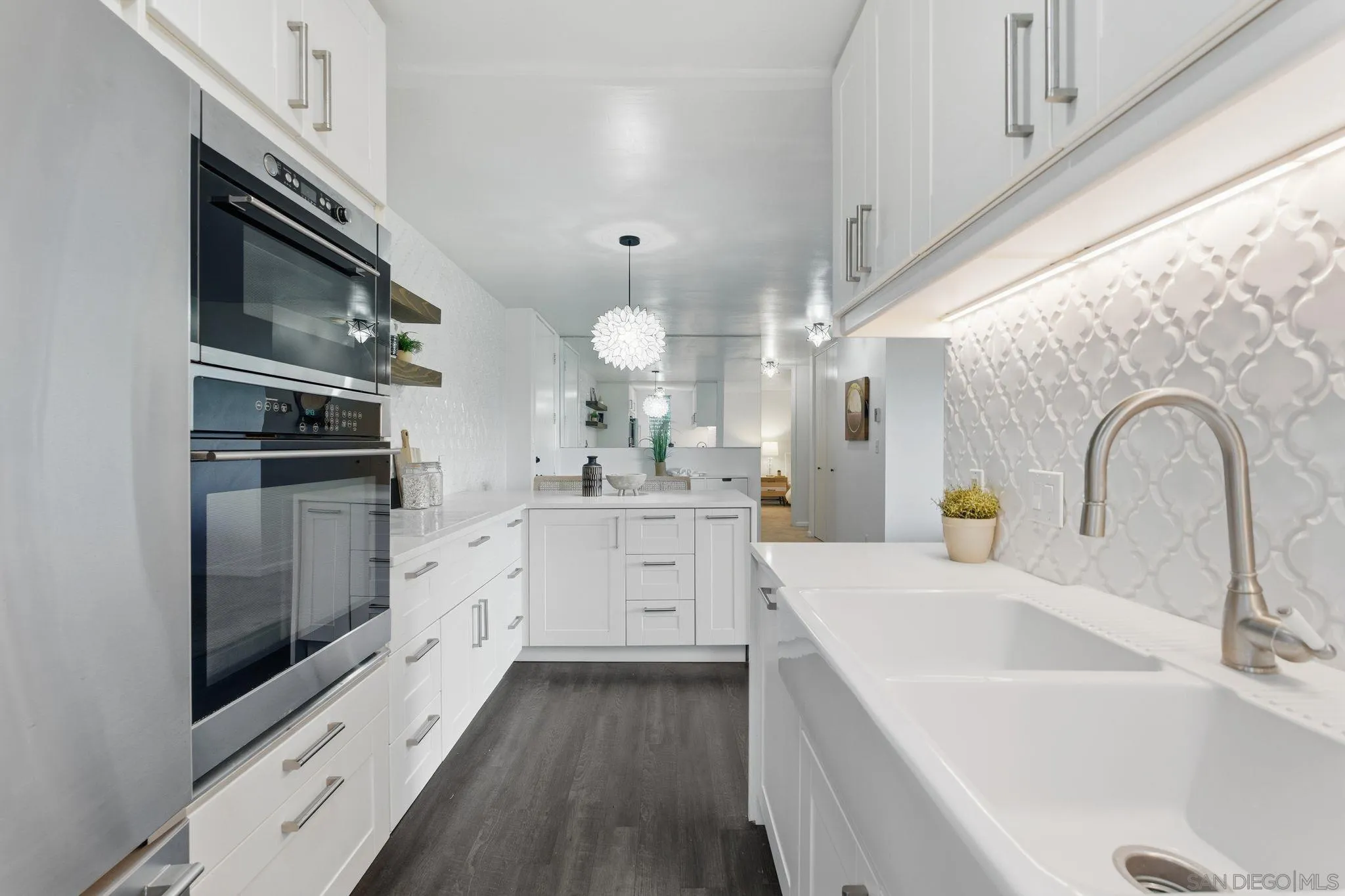 6455 La Jolla Boulevard, Unit 206 La Jolla, CA 92037 - Photo 4 of 24 a kitchen with white cabinets a sink appliances and a counter space