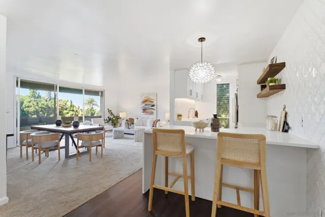 a dining room with wooden floor a chandelier a wooden table and chairs