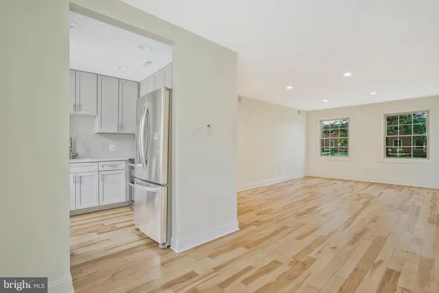 a view of a kitchen with a sink and dishwasher a refrigerator with wooden floor