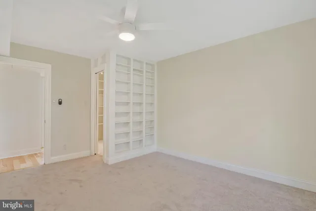 an empty room with closet and windows
