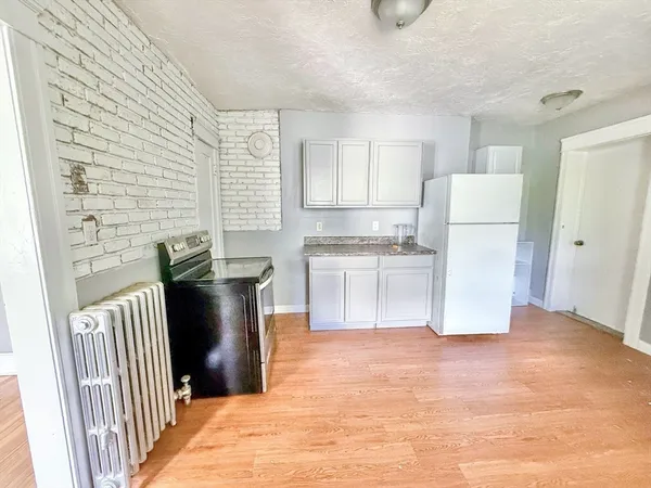 a kitchen with stainless steel appliances granite countertop a refrigerator a stove and a sink