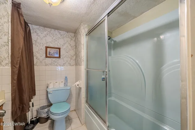 a view of an empty room with wooden floor and furniture
