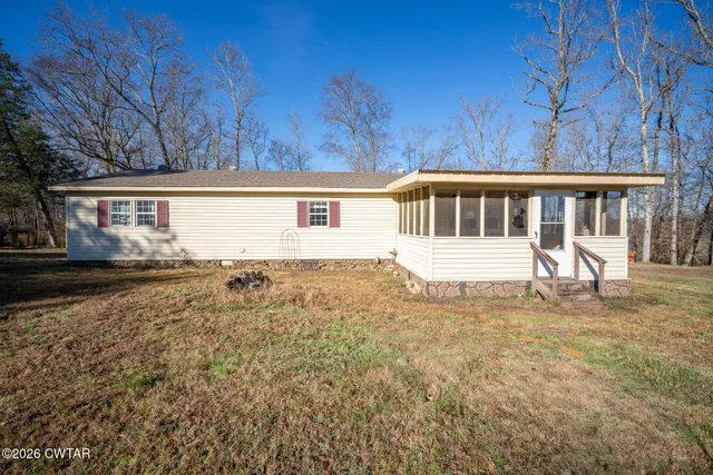 a kitchen filled with white cabinets a sink dishwasher and a stove with wooden floor