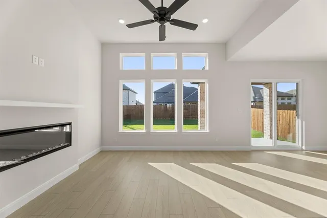 a view of an empty room with a fireplace and a window