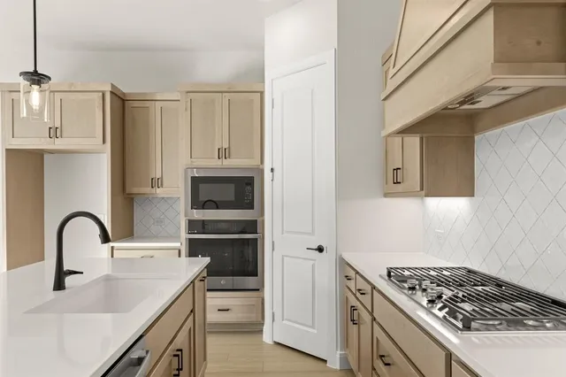 a kitchen with stainless steel appliances granite countertop a sink a stove and a refrigerator