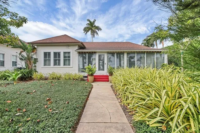 a front view of a house with a yard and potted plants