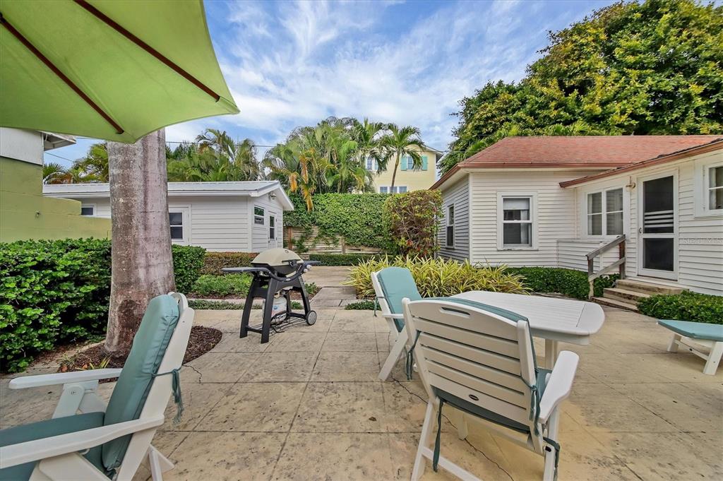 241 Gilchrist Avenue, Unit C Boca Grande, FL 33921 - Photo 23 of 23 a view of a patio with table and chairs under an umbrella