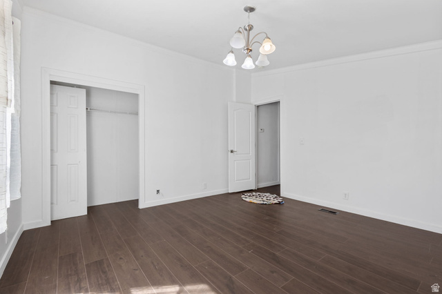 2600 North Hill Field Road, Unit 86 Layton, UT 84041 - Photo 18 of 25 Unfurnished bedroom featuring crown molding, a closet, a chandelier, and dark wood-style flooring