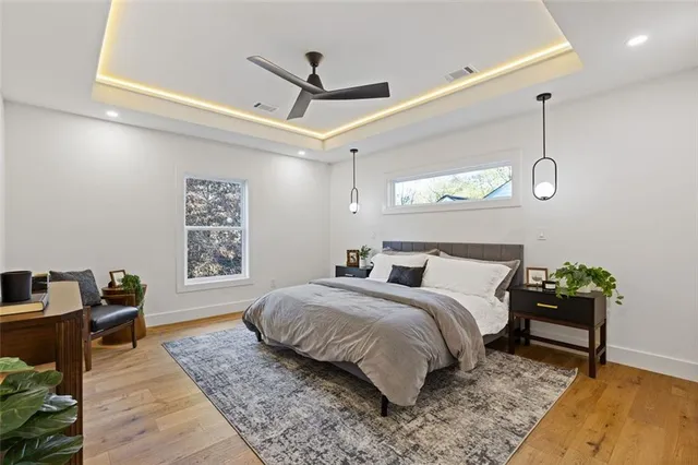 a spacious bedroom with a bed a dresser and a window