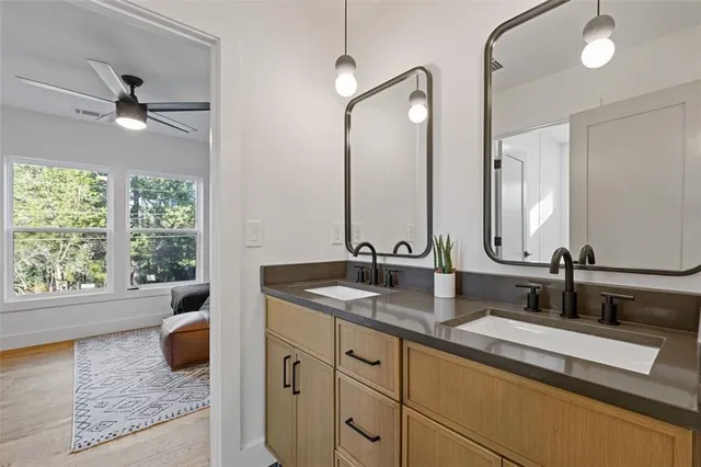 a bathroom with double vanity sinks a vanity and a large mirror