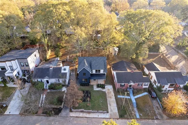 an aerial view of residential houses with outdoor space and parking