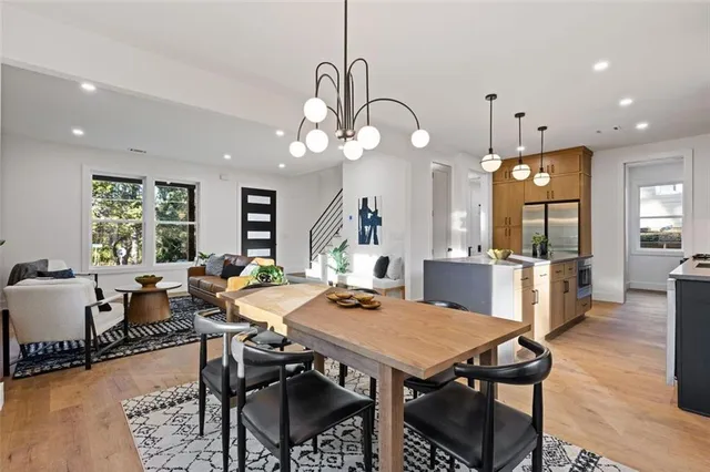a view of a dining room and livingroom with furniture wooden floor a rug a chandelier and a view