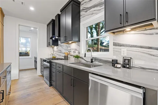 a kitchen with stainless steel appliances granite countertop a sink stove and cabinets