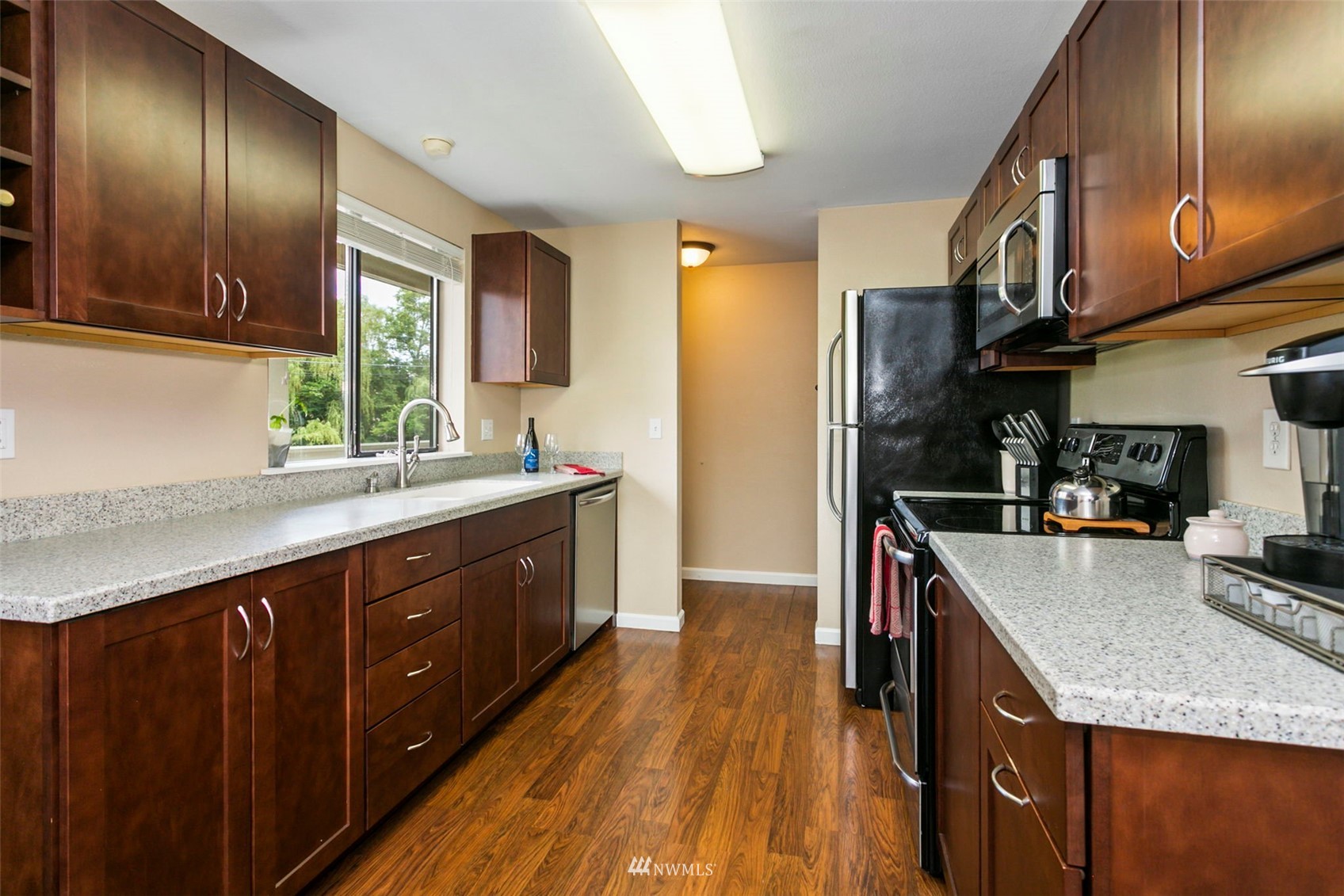 1806 201st Place Southeast, Unit 1D Bothell, WA 98012 - Photo 11 of 20 a kitchen with stainless steel appliances granite countertop a sink a stove and a wooden floors