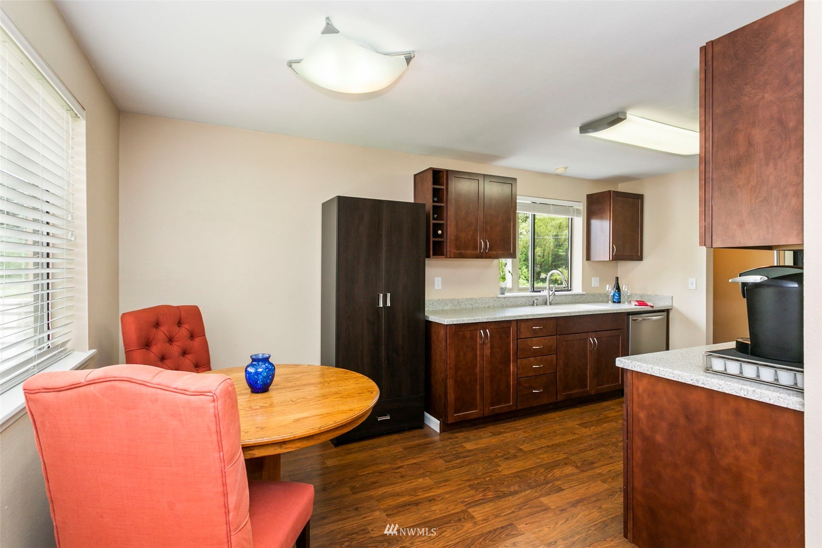 1806 201st Place Southeast, Unit 1D Bothell, WA 98012 - Photo 8 of 20 a kitchen with stainless steel appliances kitchen island granite countertop a refrigerator a stove a sink dishwasher with a dining table and chairs